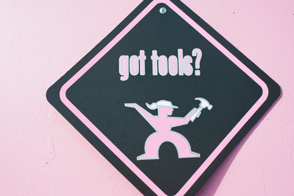 A sign hangs on the pink door to Tomboy Tools.