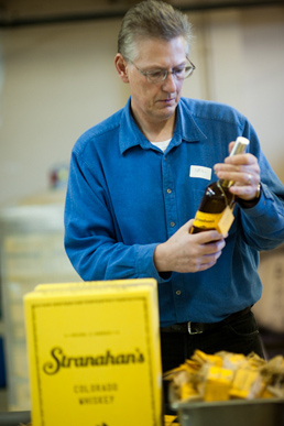 A volunteer quality checks each Stranahan's bottle.