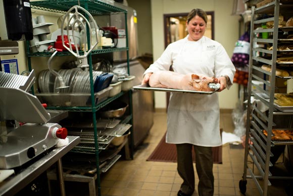 Panzano's Executive Chef Elise Wiggins carries a butchered and cured pig that will be baked and served as suckling porchetta.