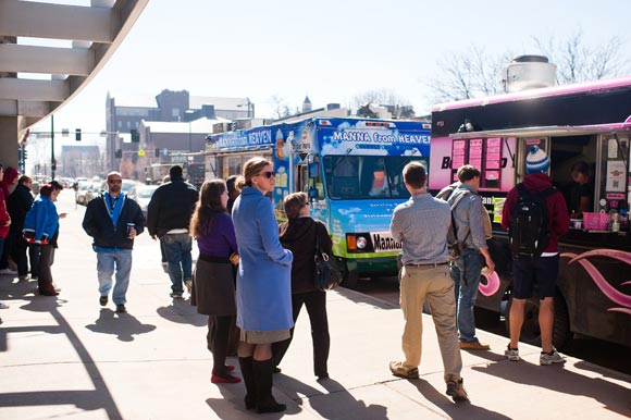 People line up for lunch outside the Food Truck Row near the University of Denver. 