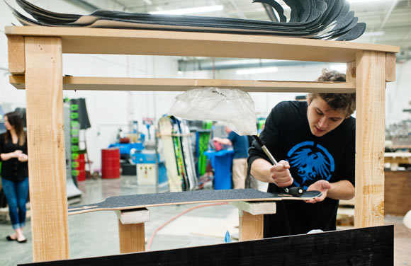 A Never Summer employee assembles one part of their longboard. 