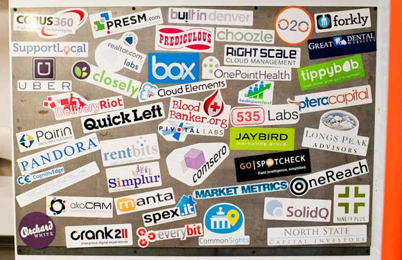 Startups' logos decorate the wall at Galvanize. 