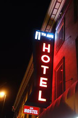 The neon sign for the 11th Avenue Hotel and Hostel lights up Broadway.