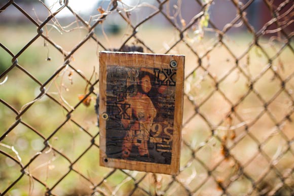 A random piece of art hangs from a fence.