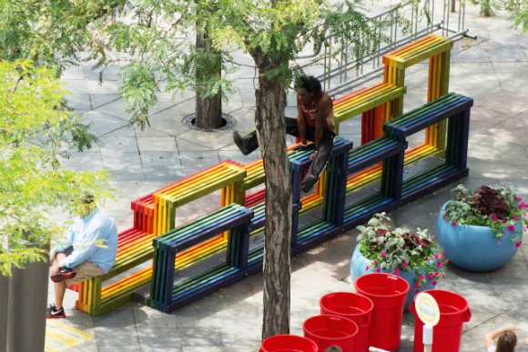 A performer uses Nick Fish's Rainbow Street Seating as a stage.