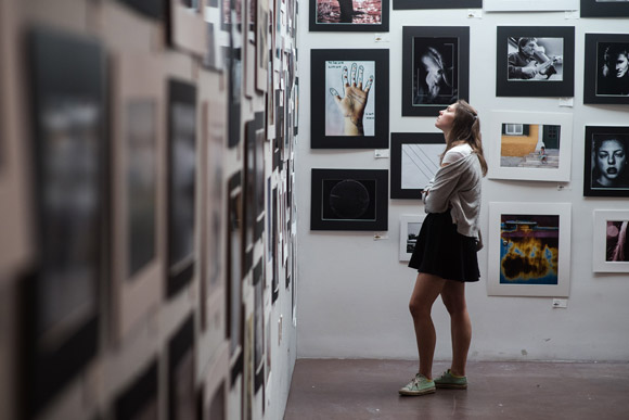 A young woman looks at the photographs on display in MCA Denver's Teen Lounge.