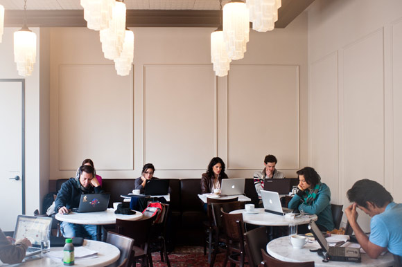 People work in the coffee shop area of The Desk.