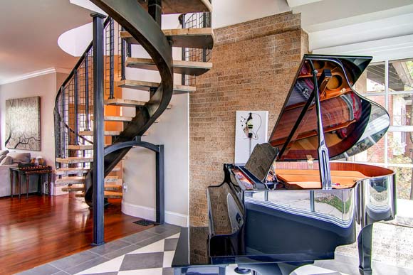 These custom stairs built on-site allowed the homeowners to expand their one story bungalow while keeping its original character. The repurposed, bleached oak treads are supported on a blackened steel central stringer backbone with a welded wire rail