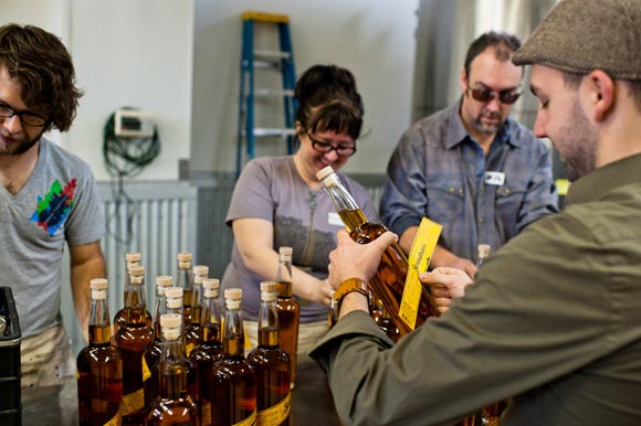 Volunteers bottle Stranahan's whiskey.