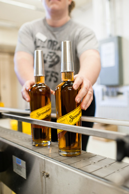 A volunteer pulls Stranahan's whiskey off the line.