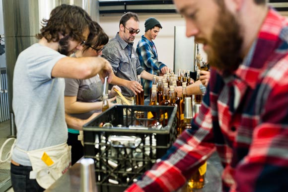 Volunteers form an assembly line to bottle Stranahan's whiskey. 