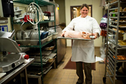 Panzano's executive chef Elise Wiggins carries out a butchered and cured pig that will be baked and served as suckling porchetta.