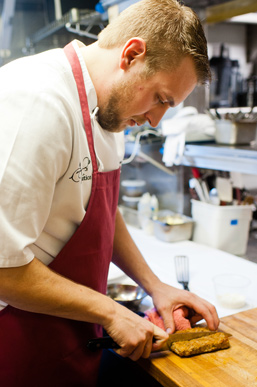 Fruition Restaurant's Chef de Cuisine Matt Vawter slices up pork shoulder for a dish.