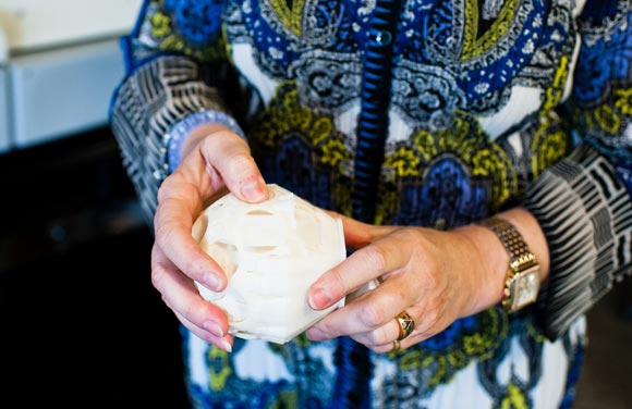 Debra Wilcox breaks apart the printed mold to show the 3-d sphere. 