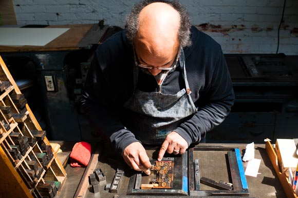 Rick Griffith puts together letters and spacers like a puzzle.