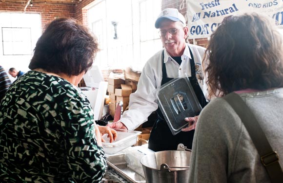 Customers try some goat cheese at Denver Urban Homesteading's farmers market.