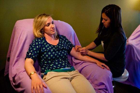 Pin & Tonic owner Lisa Bullis performs acupuncture on a client. 