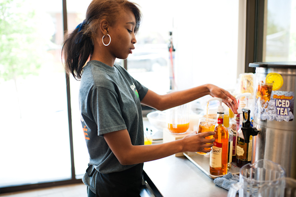 Taylor Alexander prepares drinks for a table.