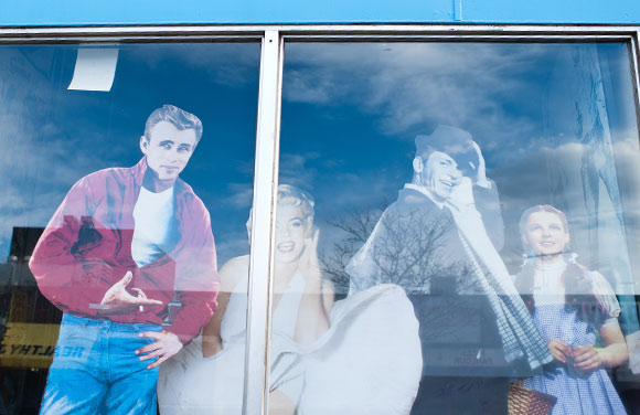 Cardboard cutouts peek out of a vacant storefront on Colfax.