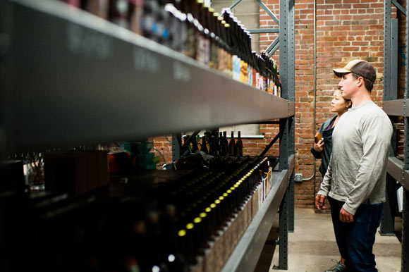 People peruse the craft beer at Proper Pour.