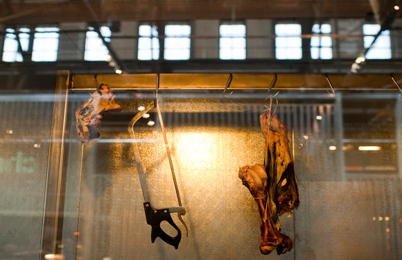 A cut of meat hangs in the window at MeatHead.