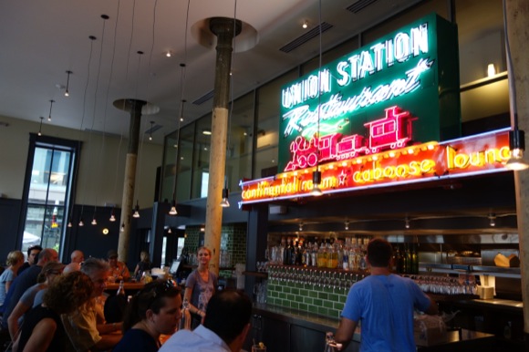 A restored 1930s neon sign hangs behind the bar at The Kitchen Next Door.