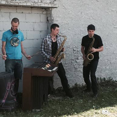 A jazz trio skronks away in an empty parking lot.