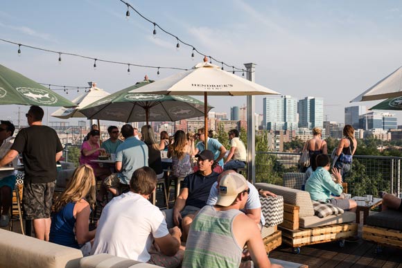 The expansive patio features furniture made from cushioned pallets on rollers.