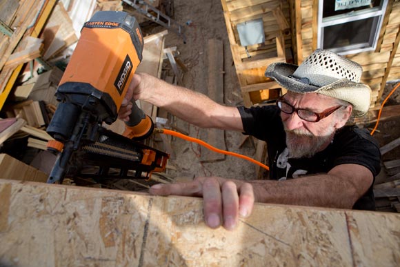 Ray Lyall nails the fascia in place on a tiny house. 