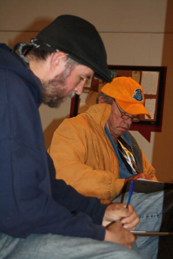 Vendors Robert Lee Payne (left) and Mick Conley work on their writing. Payne frequently contributes.