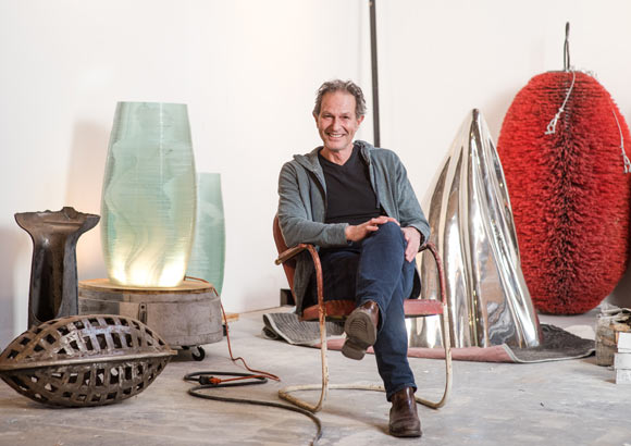 Lawrence Argent, 60, sits amid various parts of scultpures and artwork.